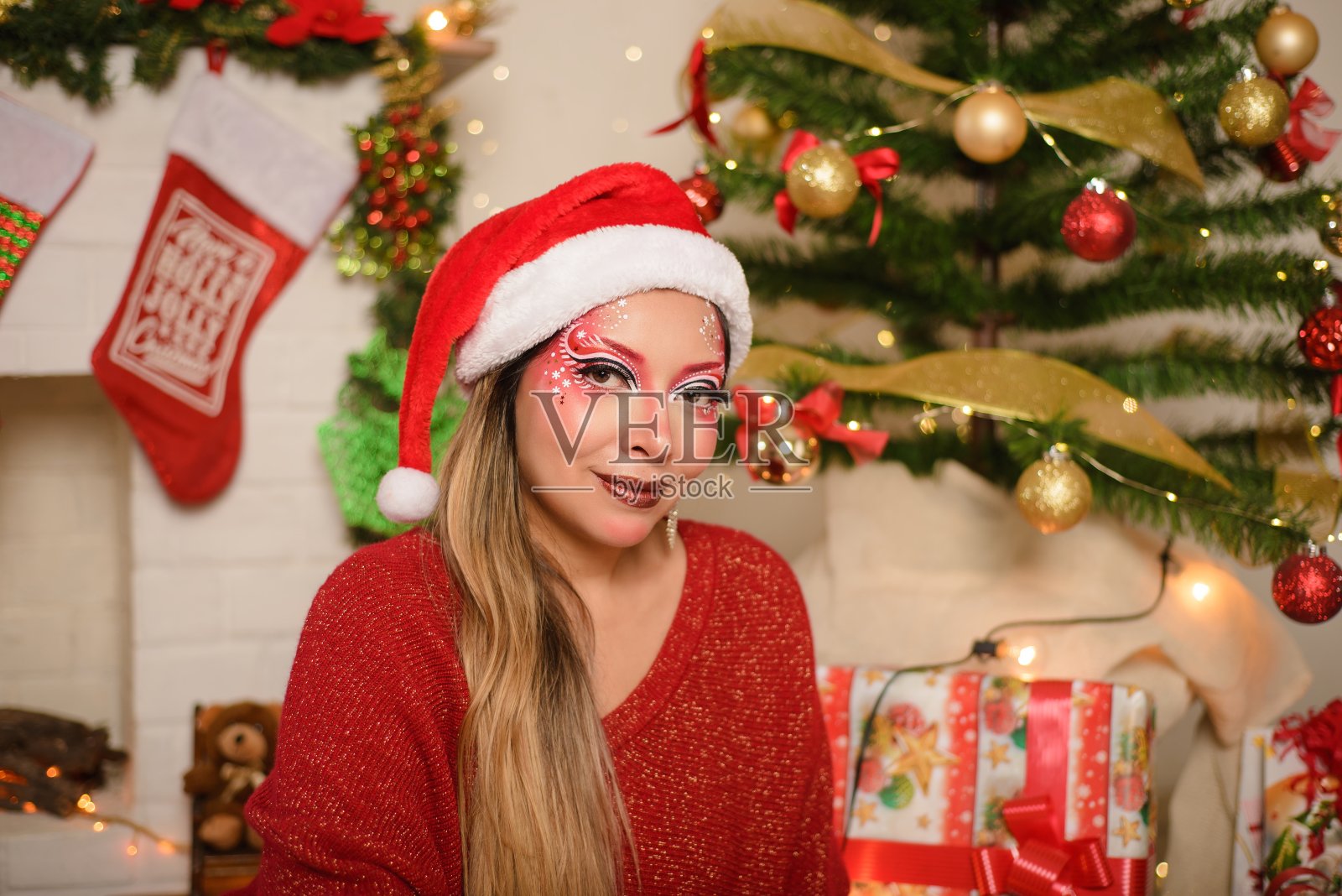 年轻女子的肖像与圣诞化妆和圣诞帽。圣诞节的背景。照片摄影图片