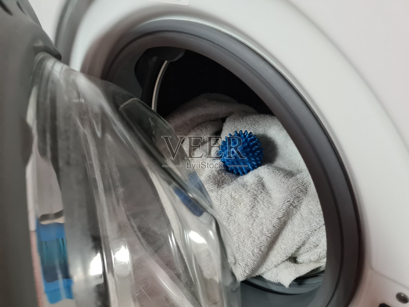 在洗衣机里洗衣服的蓝色球照片摄影图片