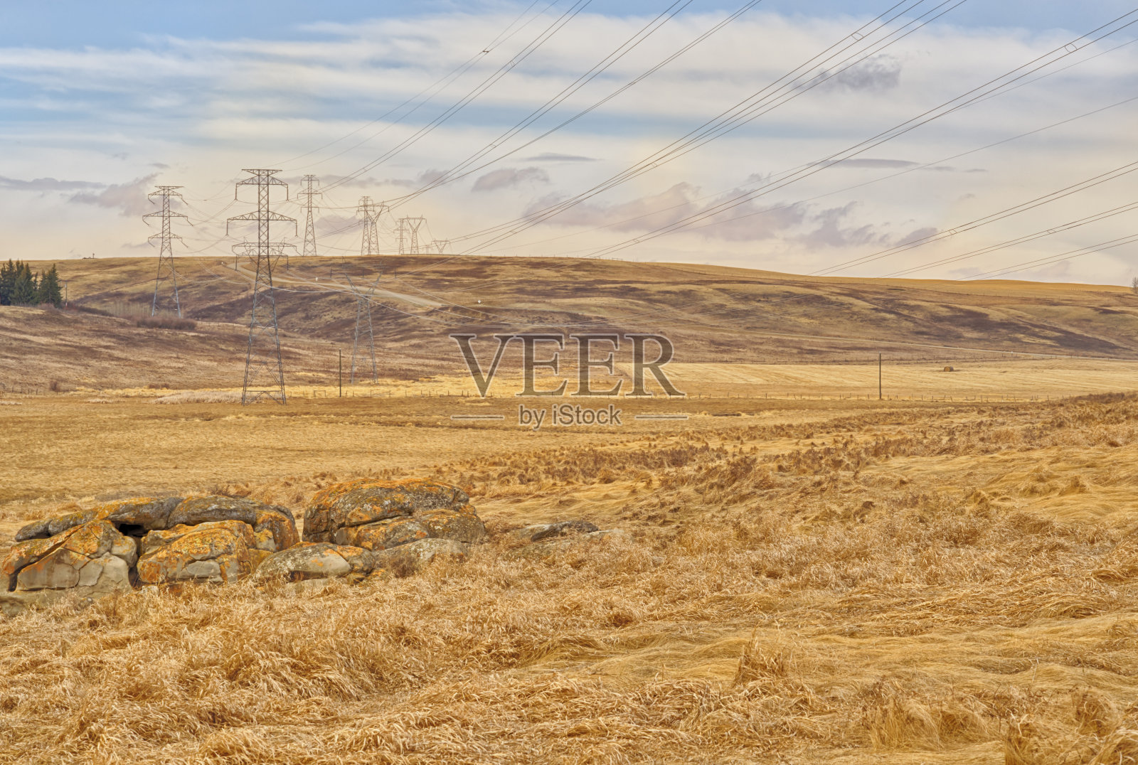 草原山麓景观与高压塔。照片摄影图片