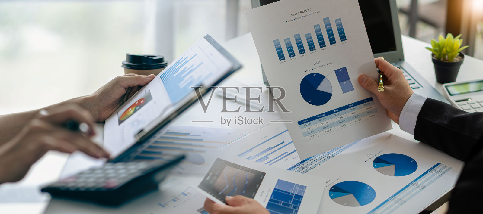 业务同事使用笔记本电脑和分析技术分析纸质文件、账目、合同、投资顾问、企业营销计划上的财务数据。照片摄影图片