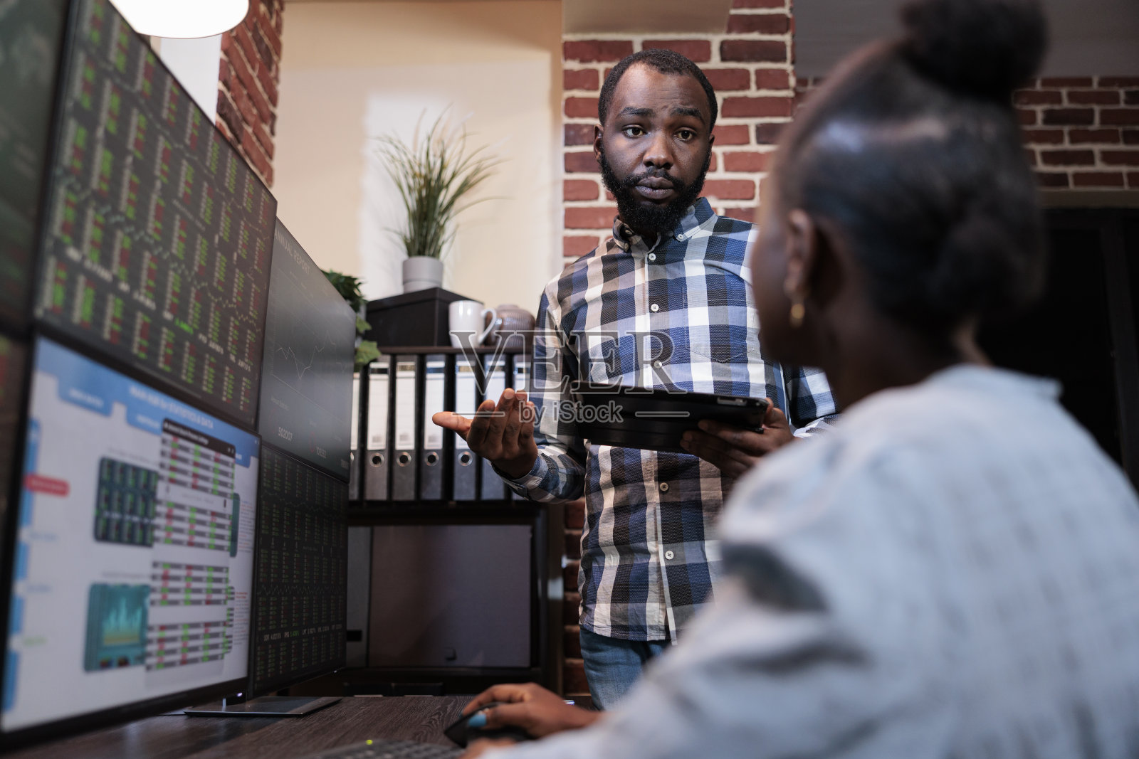 非裔美国金融投资者在办公室工作空间讨论低机会获利。照片摄影图片