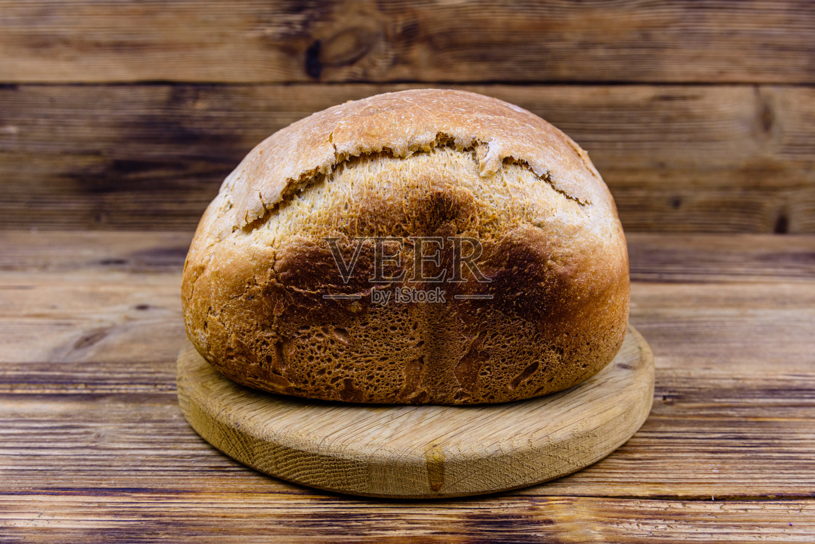 木桌上的一条刚烤好的面包照片摄影图片