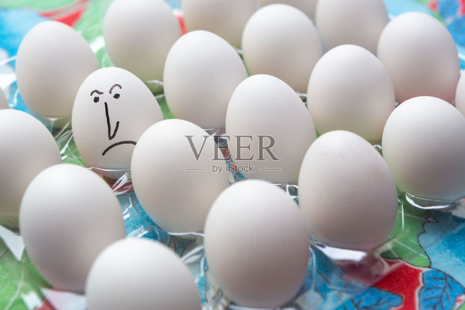 特写的白色鸡蛋与愤怒的脸和排鸡蛋孤立的颜色背景。悲伤。照片摄影图片