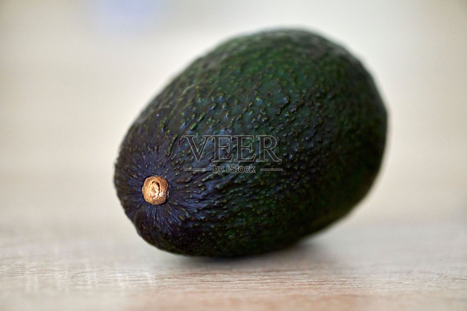 木桌上一个新鲜成熟的鳄梨特写照片摄影图片