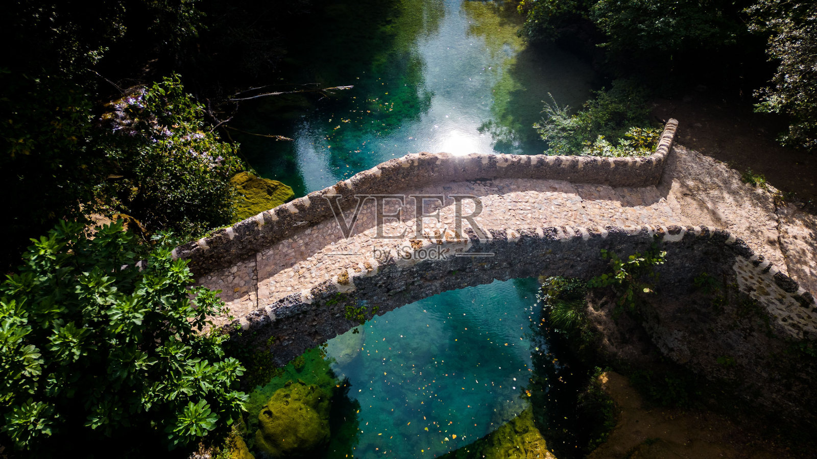 在晴朗的日子里，无人机鸟瞰干净的河流上的一座桥照片摄影图片