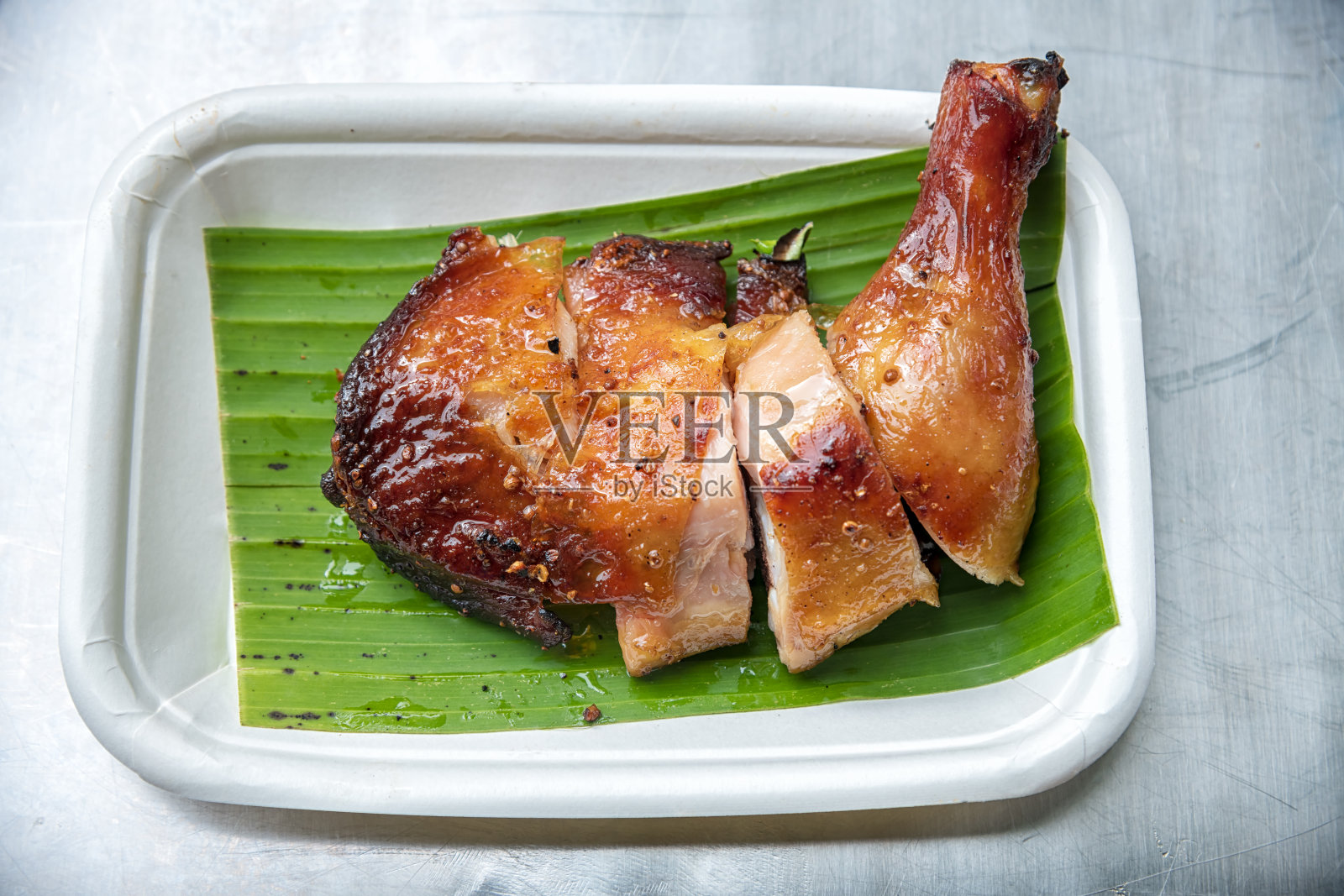 盘子里的烤鸡的特写。照片摄影图片