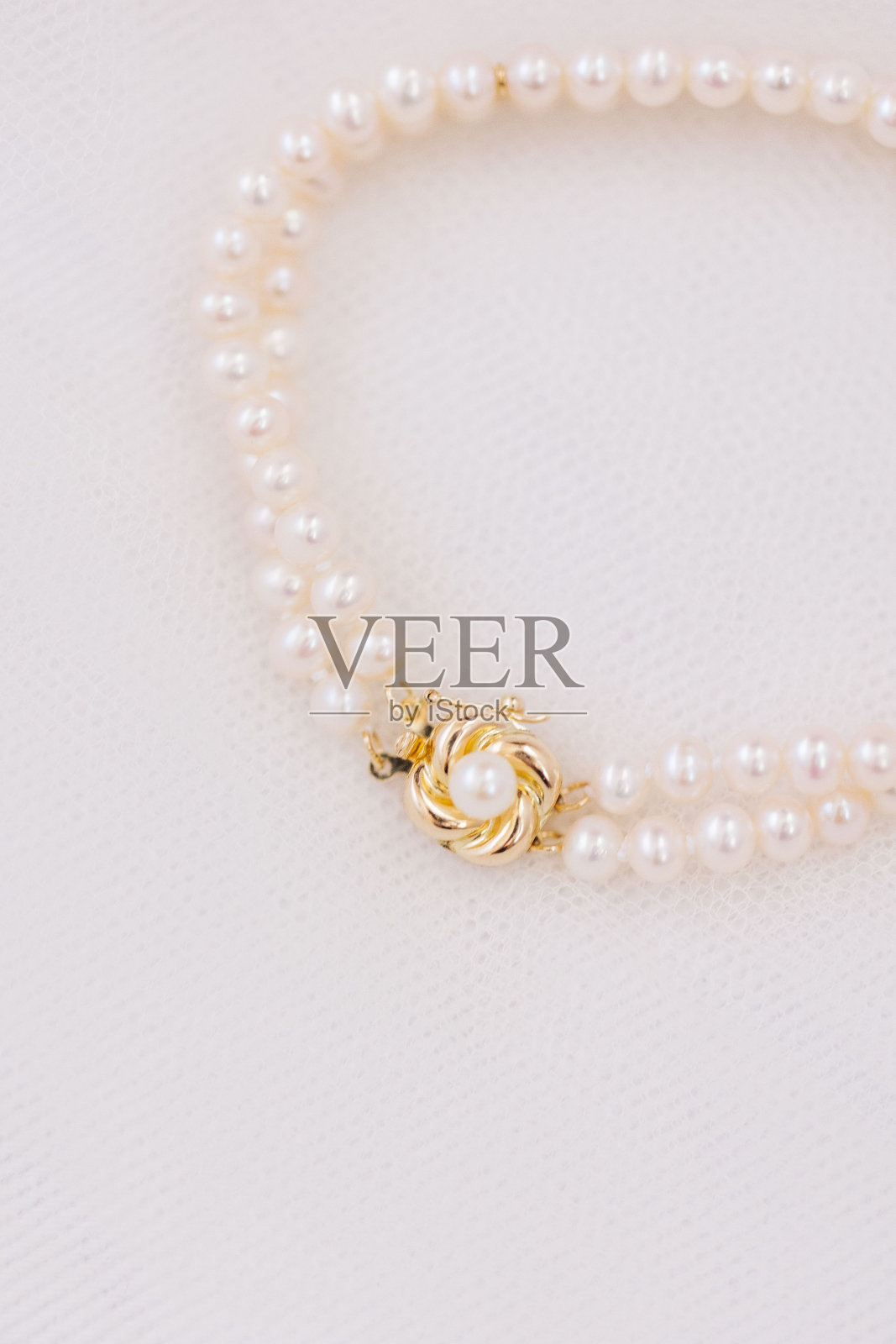 珍珠手镯与黄金细节的白色背景照片摄影图片