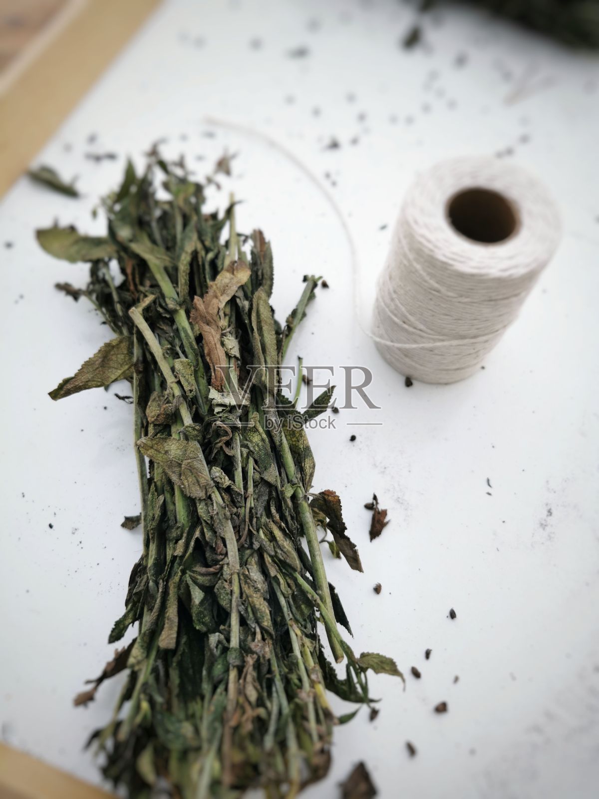 白色编织纱和绿色鼠尾草在白色表面的俯视图-准备干燥照片摄影图片