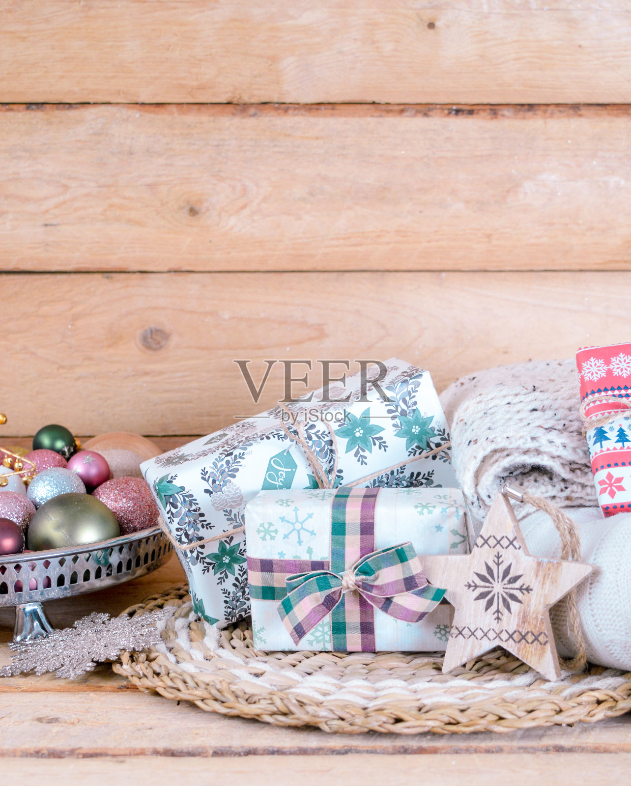 圣诞礼物放在木制地面上与圣诞装饰品和松果与毛毯照片摄影图片