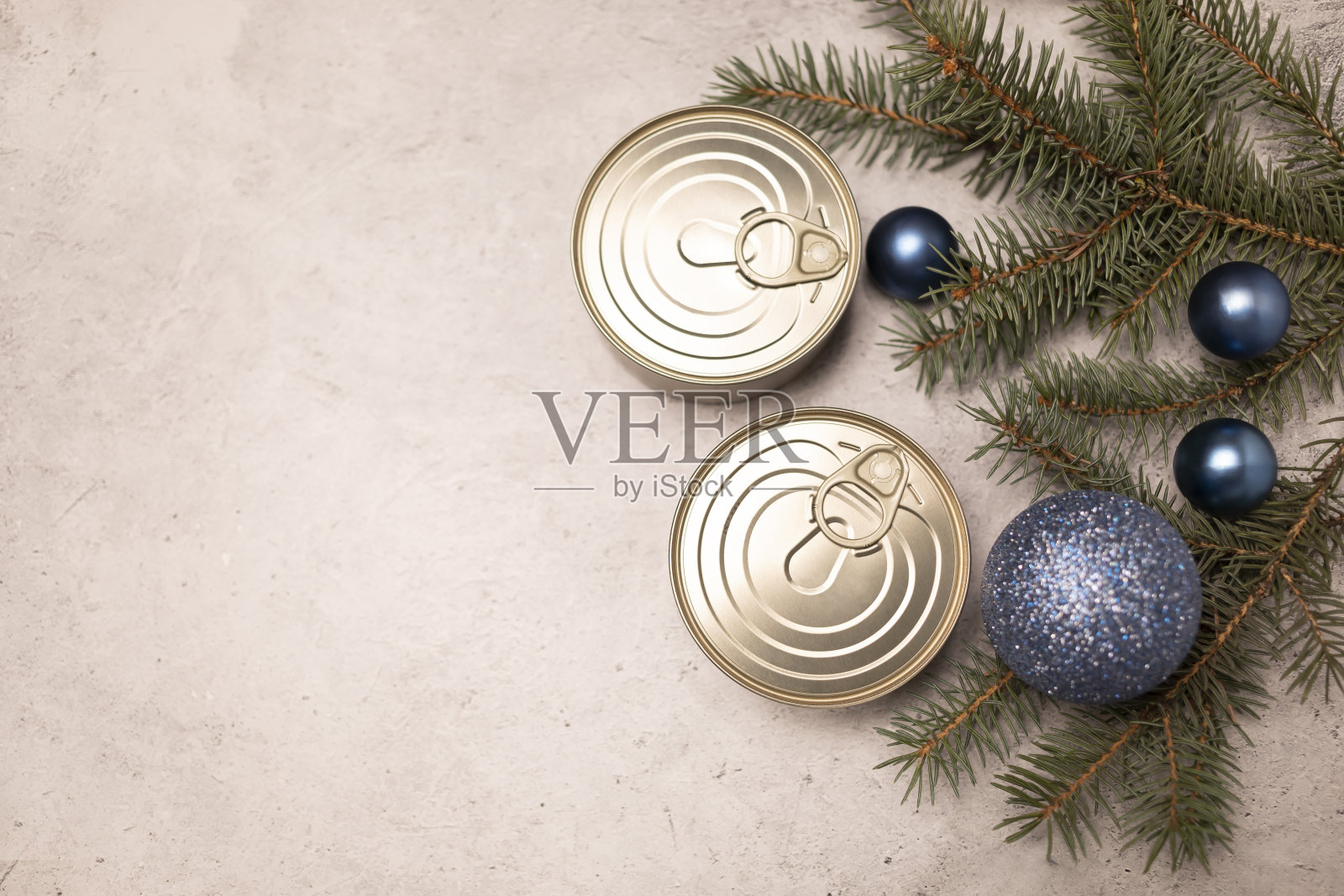 圣诞罐头产品，保存，包装鱼，肉或蔬菜在罐头混凝土背景与圣诞树和蓝色玩具球。文本空格。新年食物概念。水平断然照片摄影图片