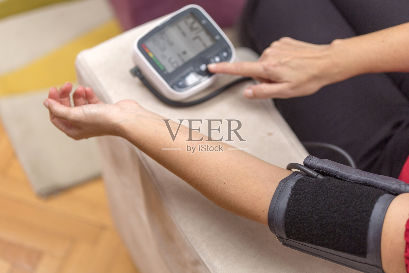 一位女士正在量她的血压。家庭保健概念。照片摄影图片