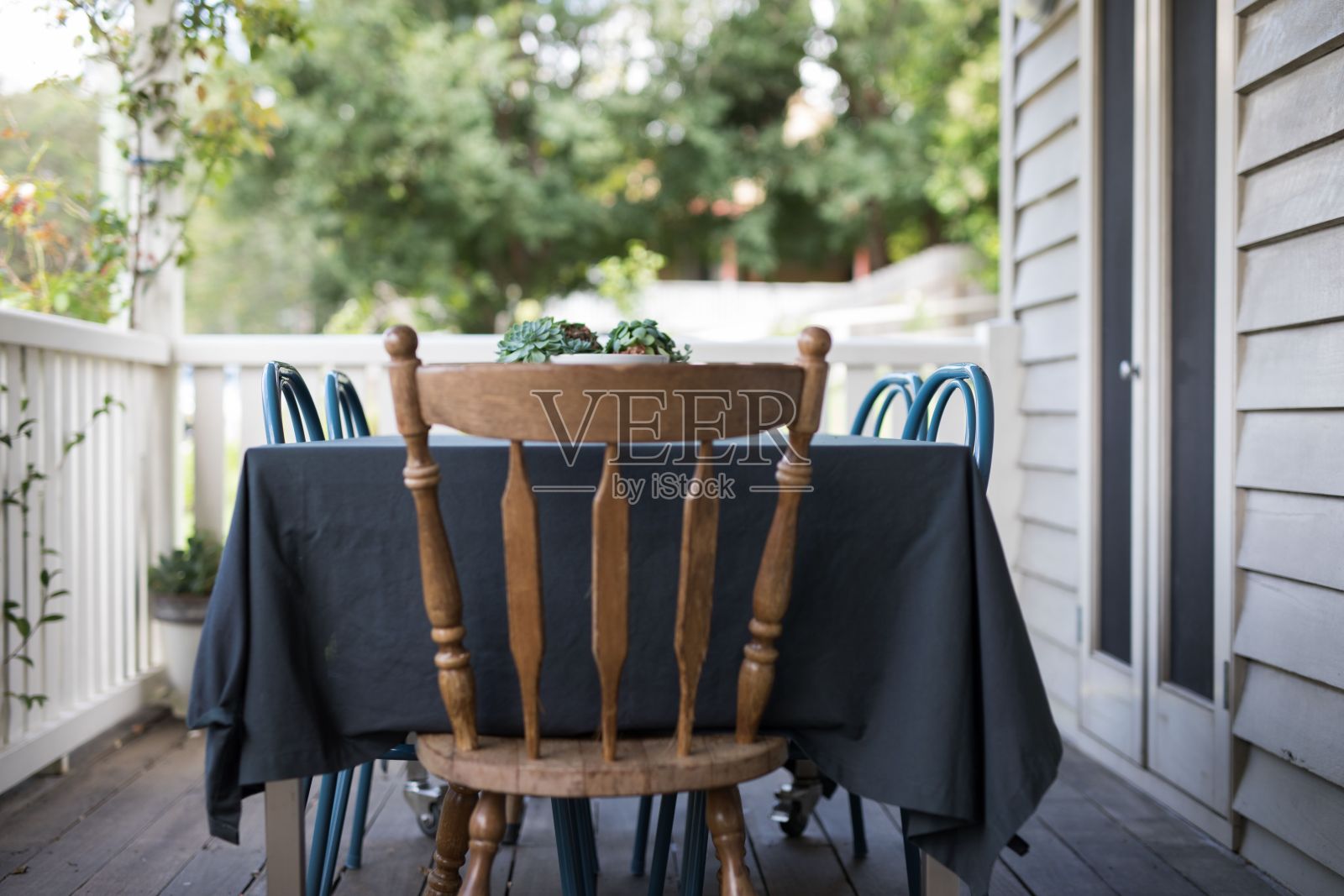 前廊的一张桌子周围有几把空椅子照片摄影图片