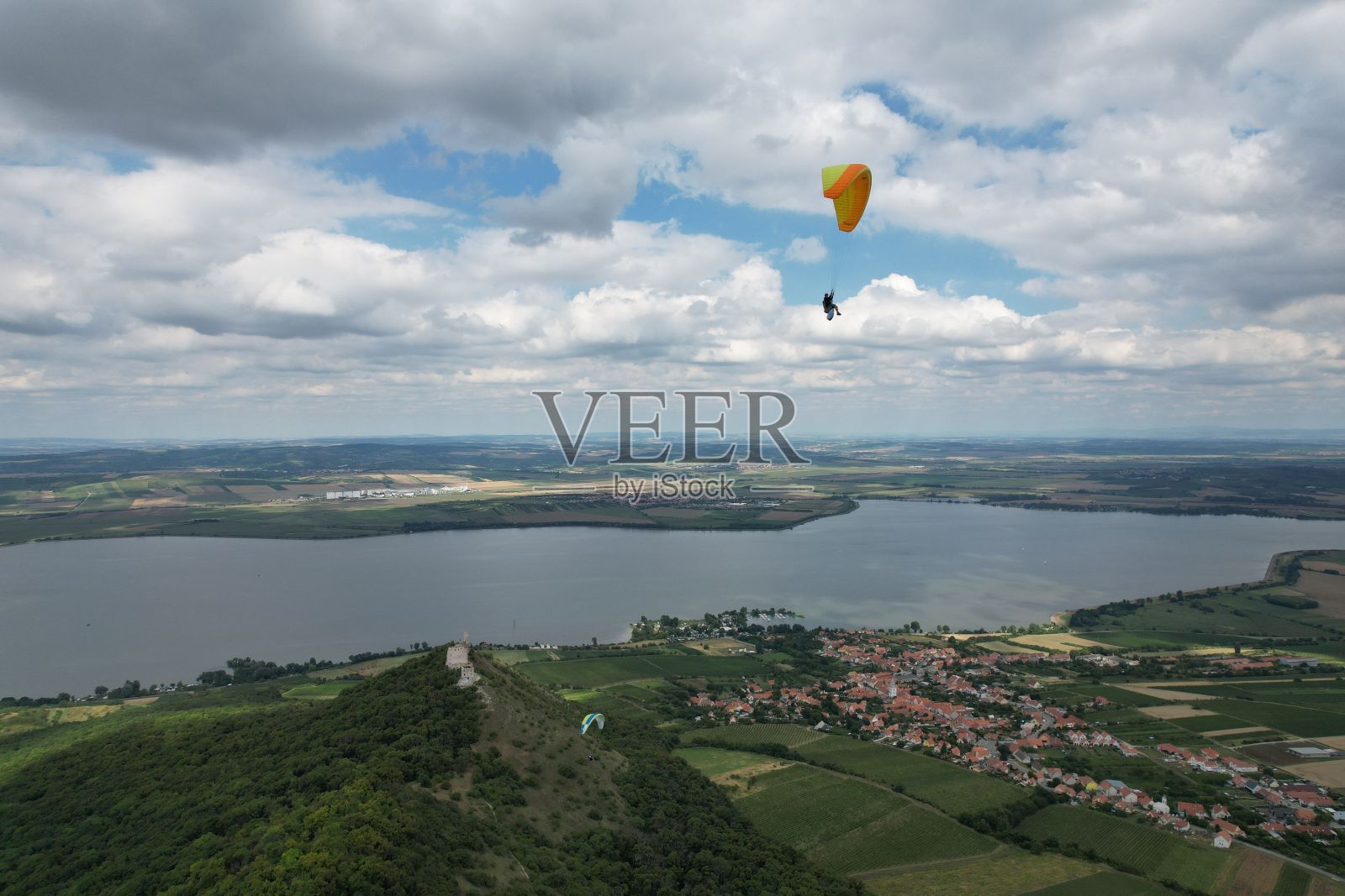 一个人滑翔伞的鸟瞰图，背景是多云的蓝天，捷克共和国照片摄影图片