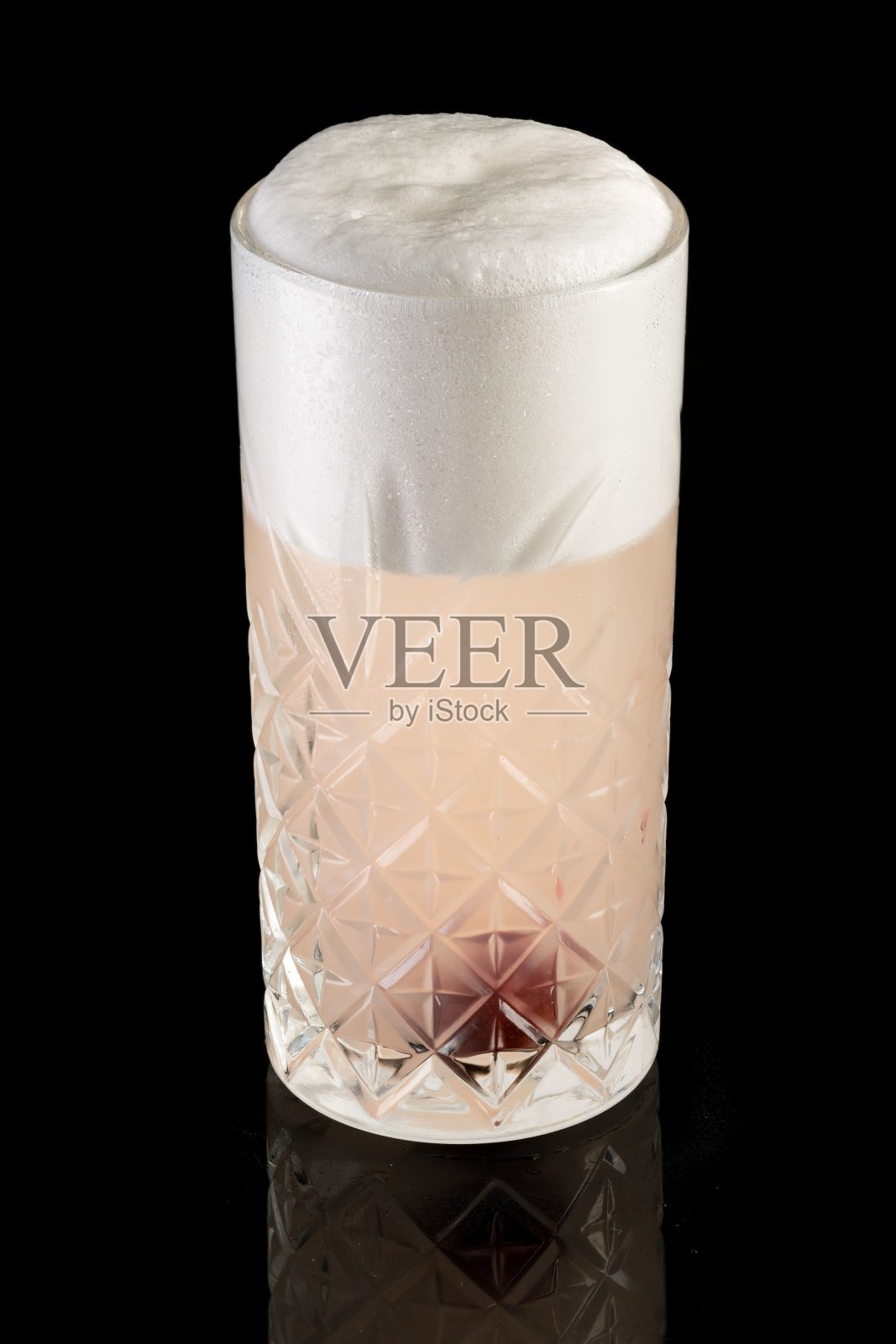 粉色鸡尾酒的垂直镜头，黑色背景上有一颗樱桃照片摄影图片