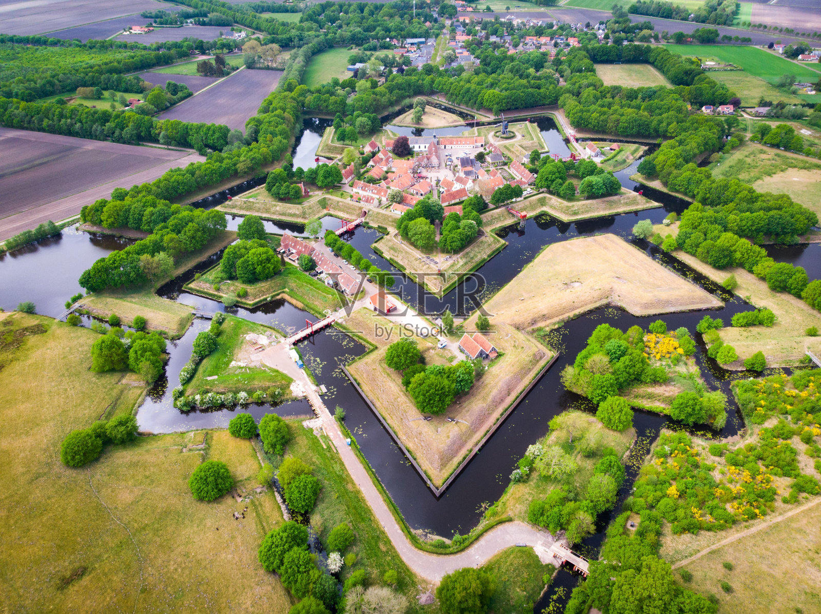 无人机拍摄的布尔坦日堡的设计，在白天周围有树木和水渠照片摄影图片