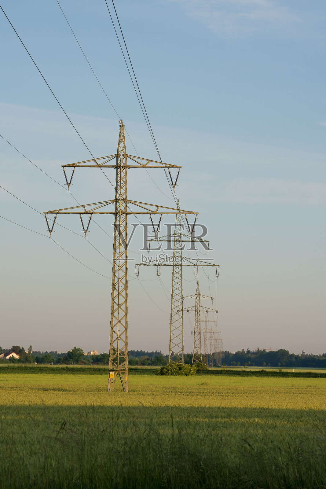 垂直拍摄的公用电线杆在开放的绿色领域与蓝天照片摄影图片