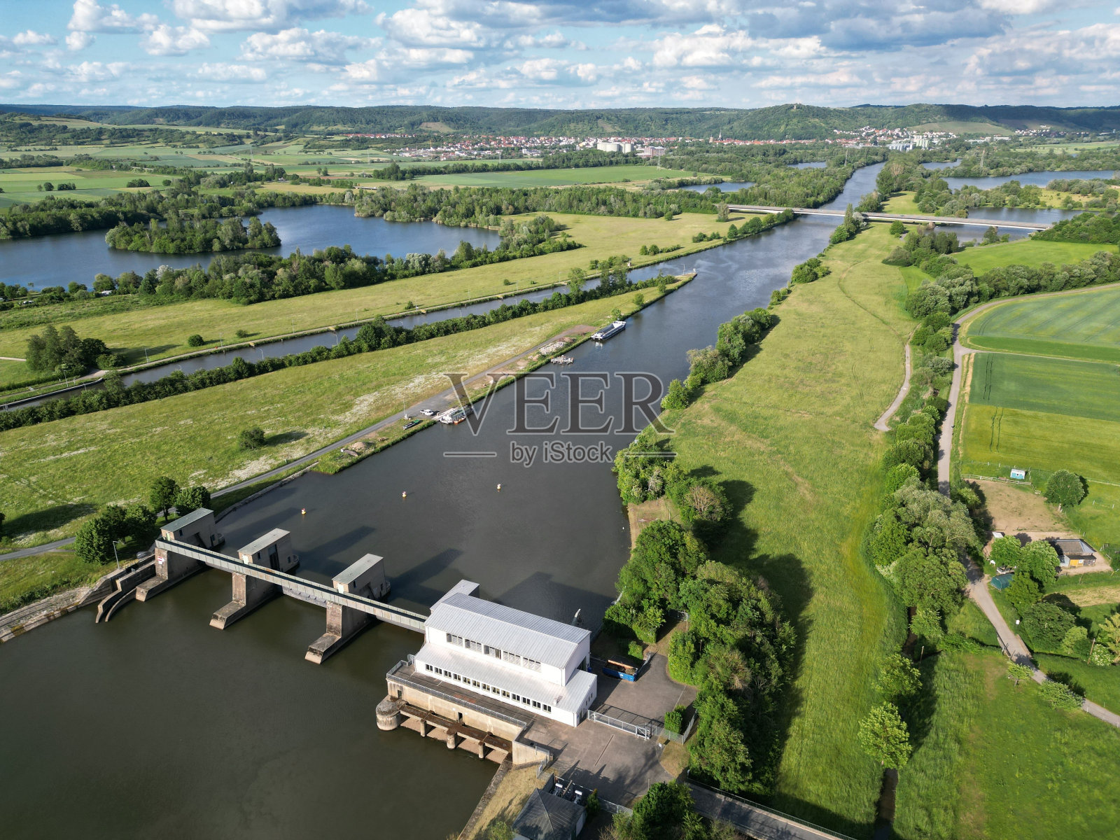 美丽的乡村景观，河流被绿色植被环绕。照片摄影图片