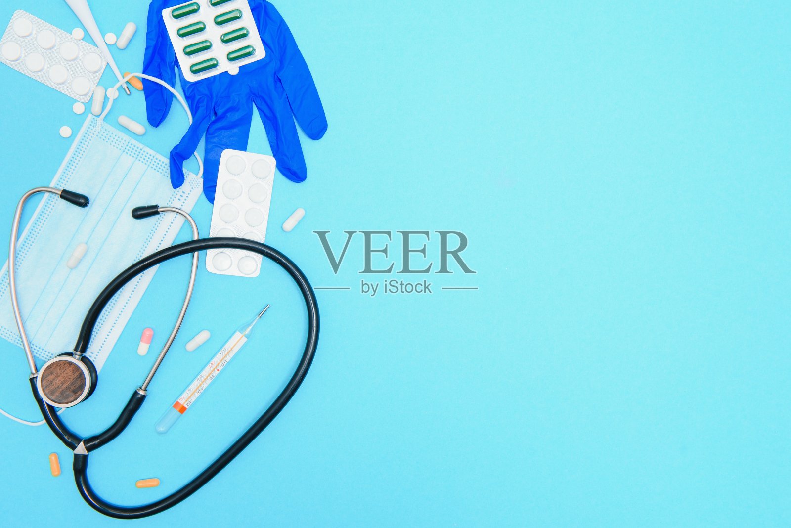 医生，护士的药品，工作工具和附件的俯视图。医疗器械——蓝色背景的药片、温度计、注射器、安瓿、胶布和静视镜。平的。照片摄影图片