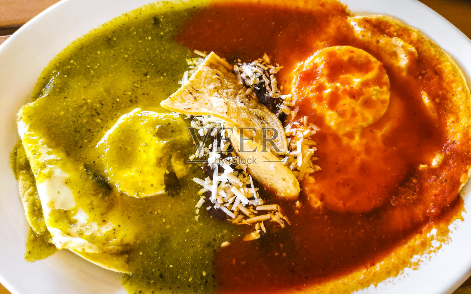 墨西哥煎蛋卷，黑豆酱，玉米片，白盘子。照片摄影图片