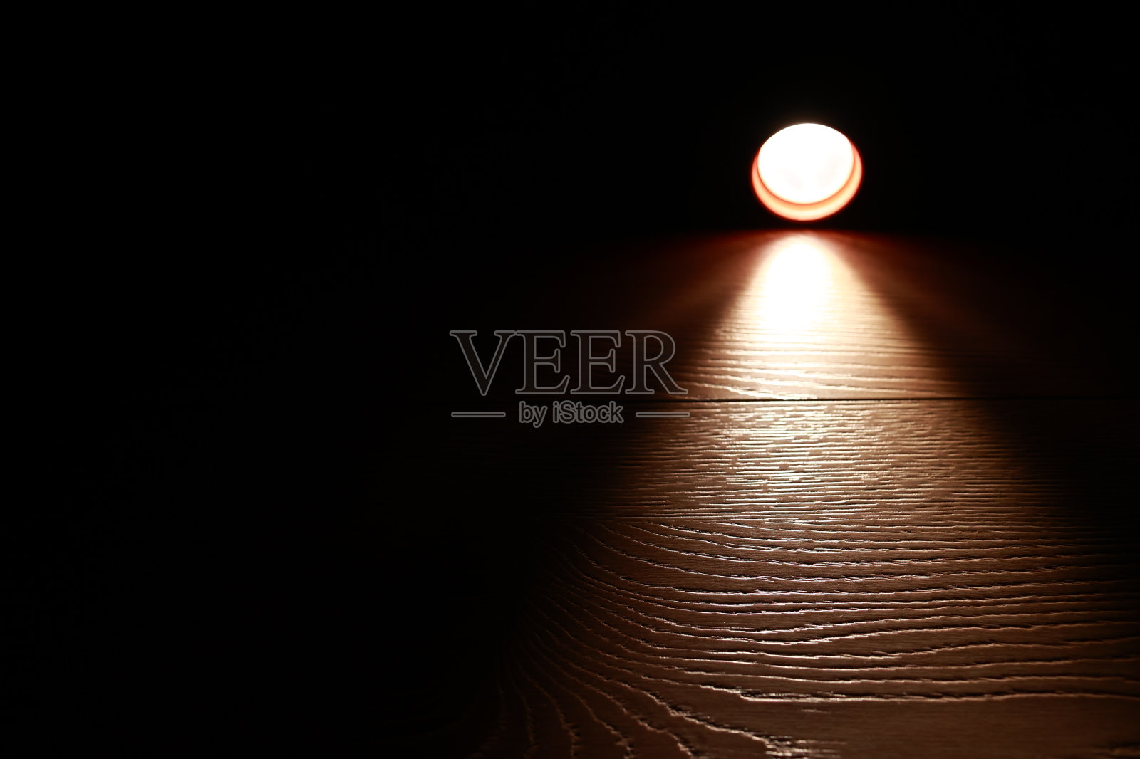 手电筒和黑暗中的一束光。现代led灯，明亮的投影在深色的木桌上。表面与复制空间。停电。电力系统崩溃。照片摄影图片