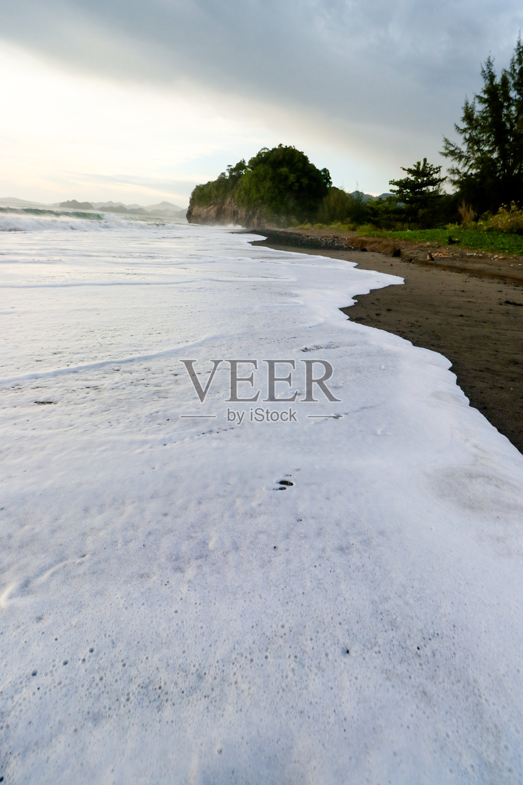 白色的海浪和黑色的沙滩照片摄影图片