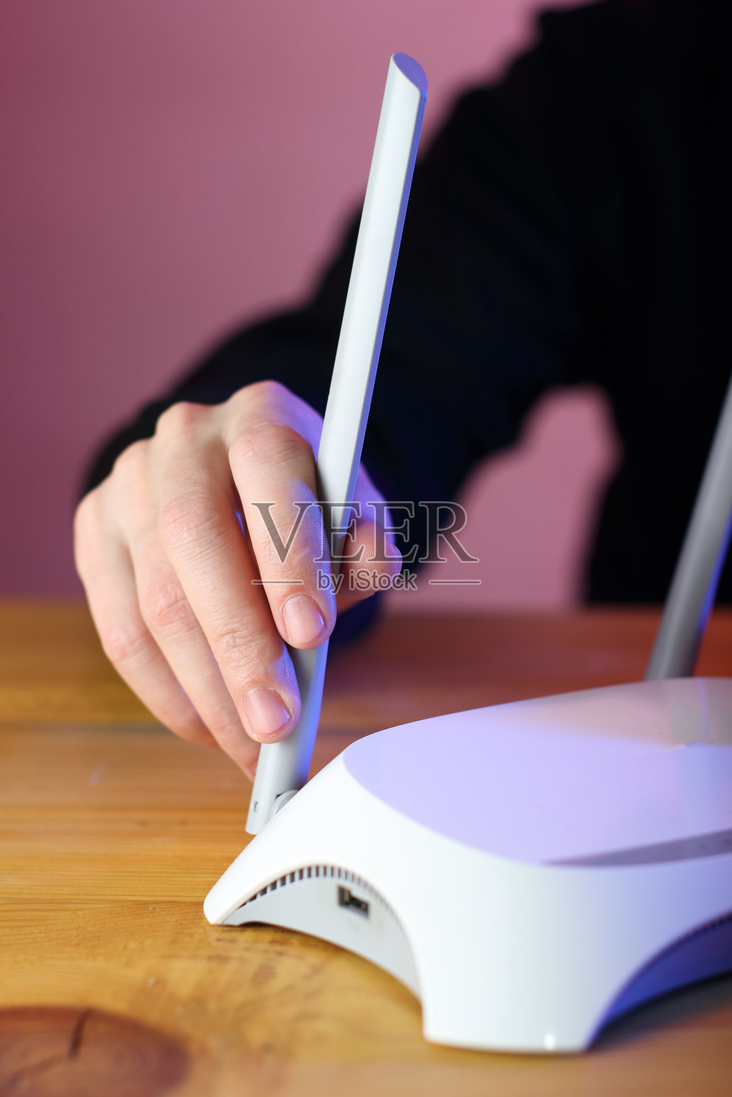 有人在木桌上设置互联网路由器天线照片摄影图片