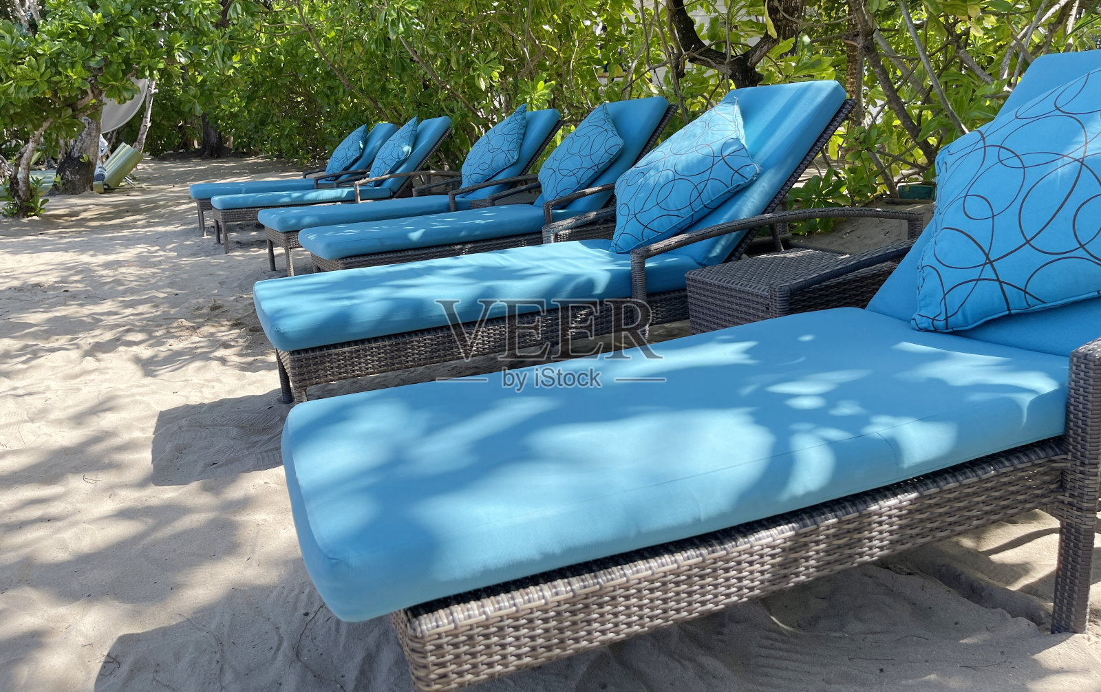 在炎热的夏天，在豪华热带酒店的白色沙滩上的躺椅或沙滩椅照片摄影图片