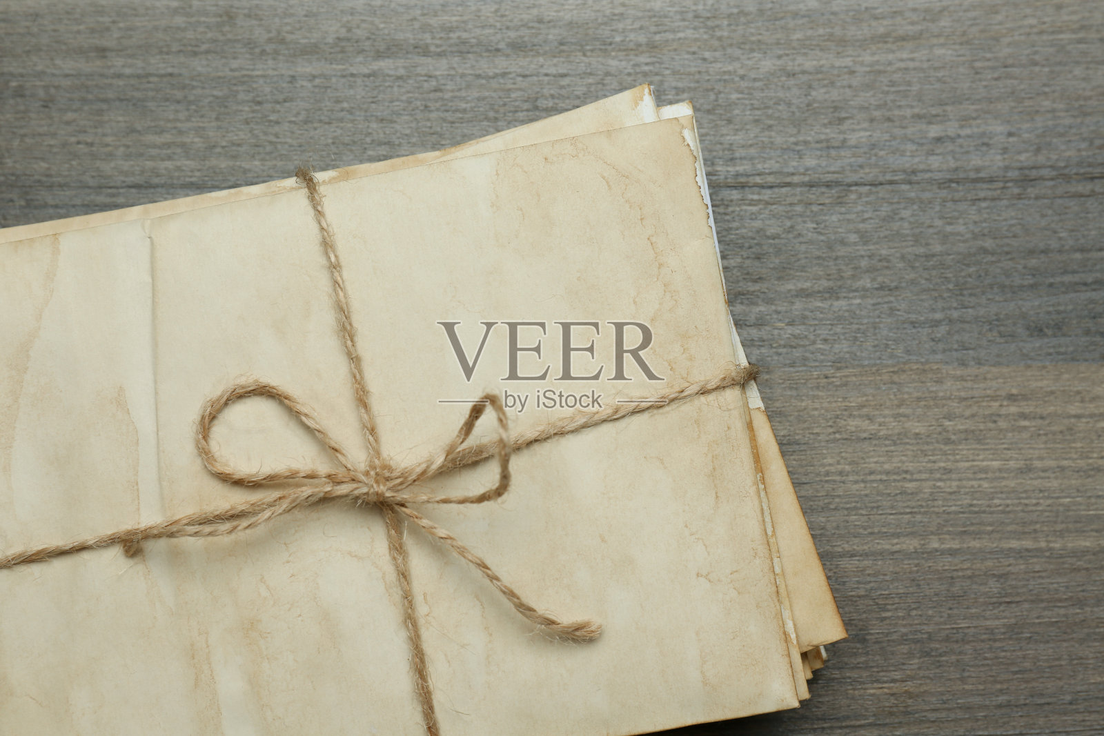 一堆旧信件用麻绳绑在木桌上，俯视图照片摄影图片