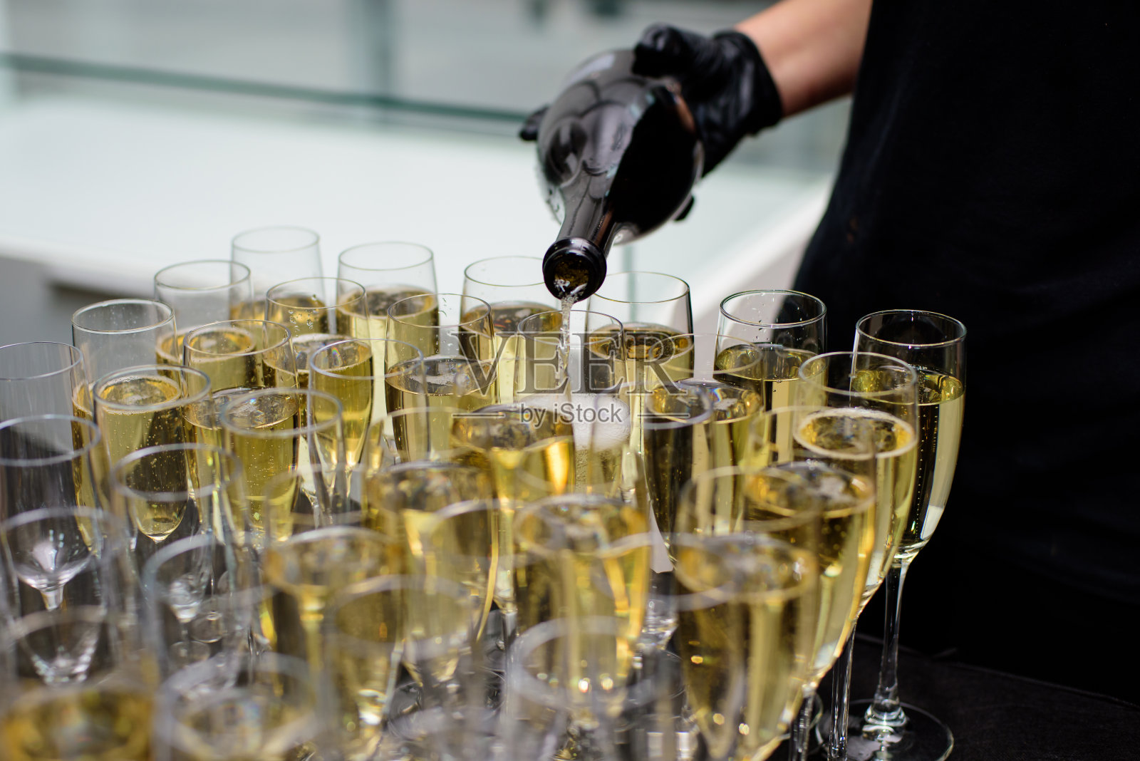 服务员把香槟倒进杯子里照片摄影图片