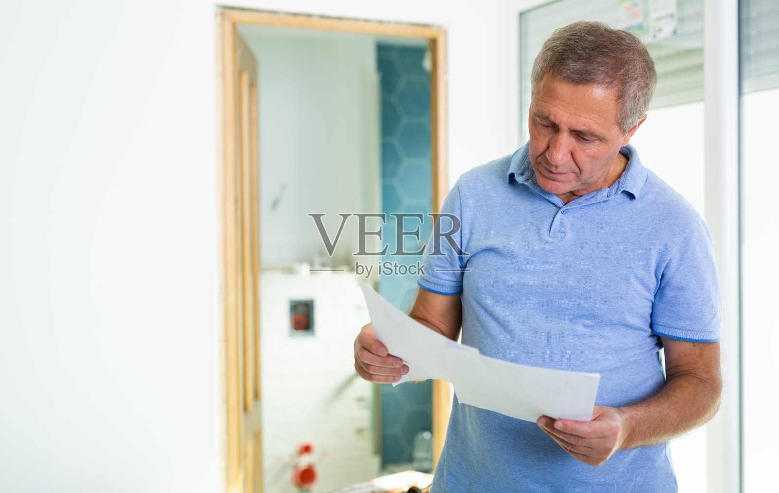 一名男子手里拿着文件，在小屋检查已完成的维修质量照片摄影图片