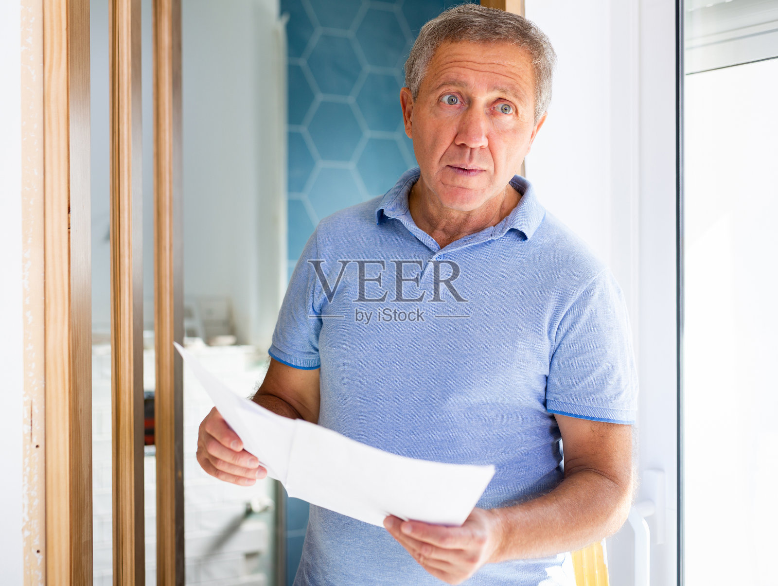 一名男子手里拿着文件，在小屋检查已完成的维修质量照片摄影图片