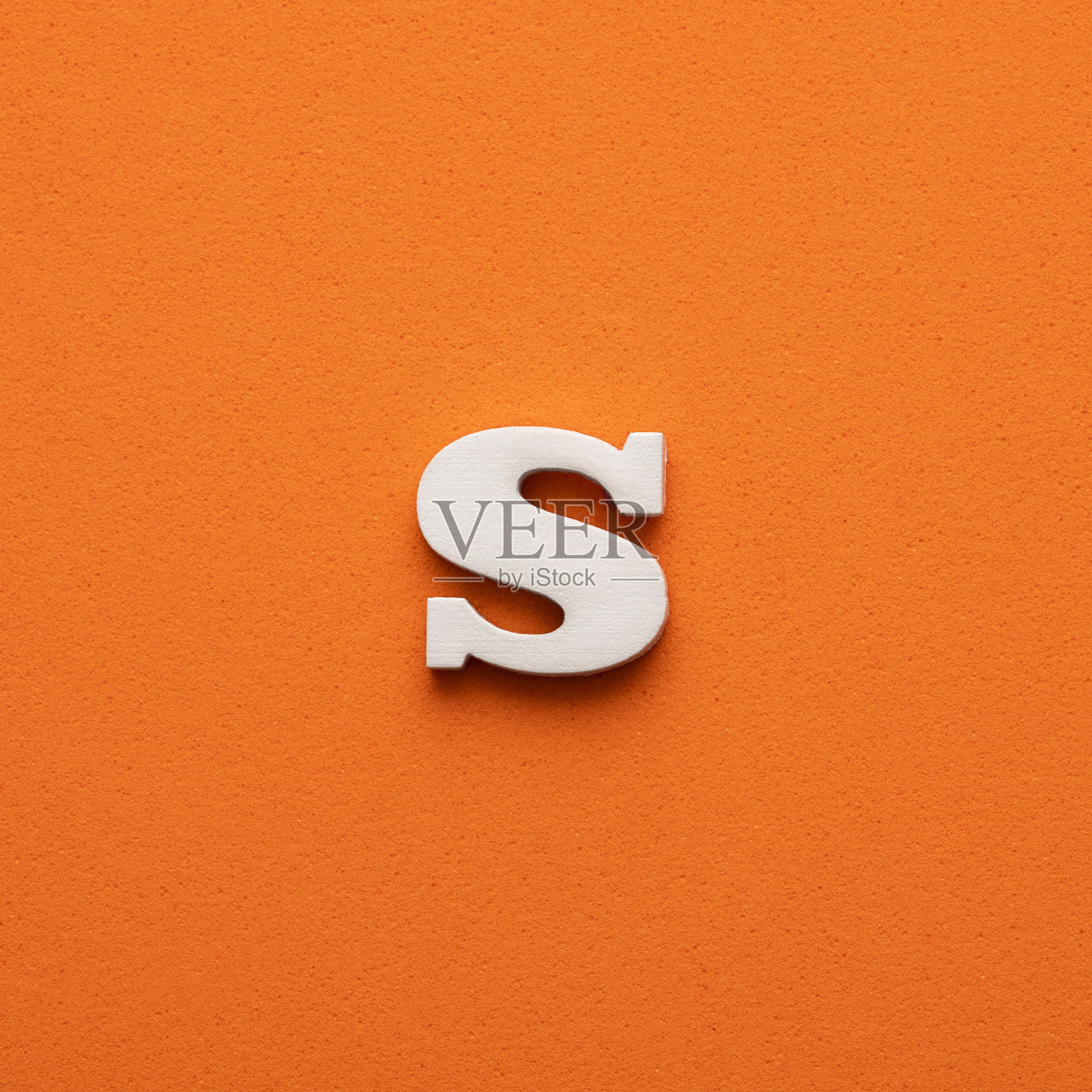 白色小写字母s在橙色泡沫背景照片摄影图片