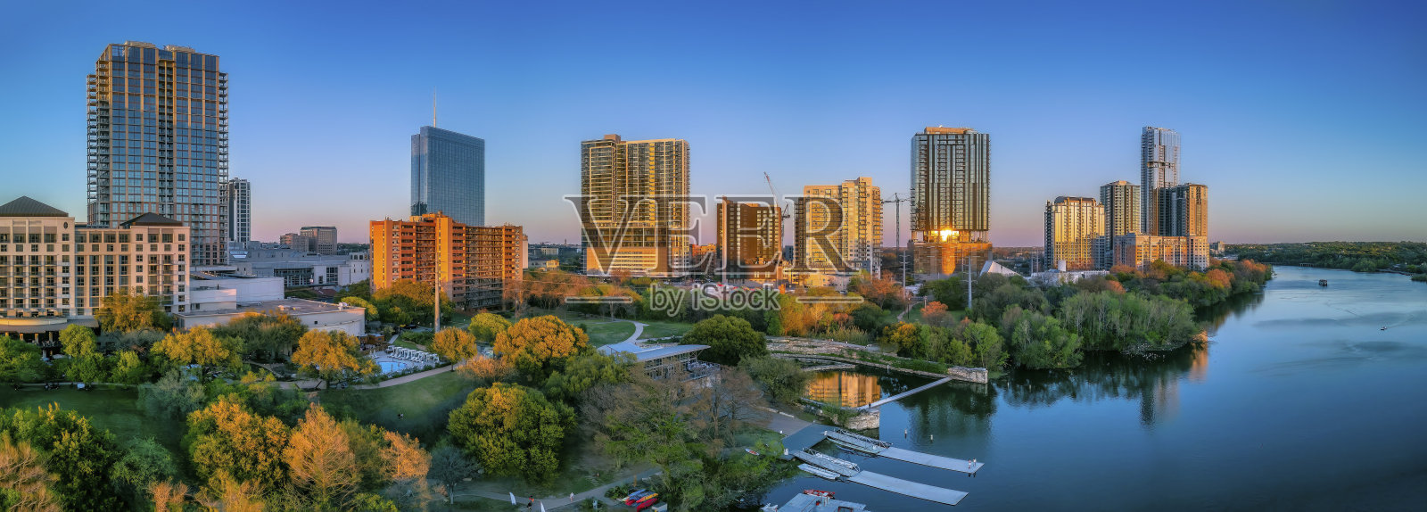 德克萨斯州奥斯汀市——日落时分科罗拉多河附近的城市景观照片摄影图片