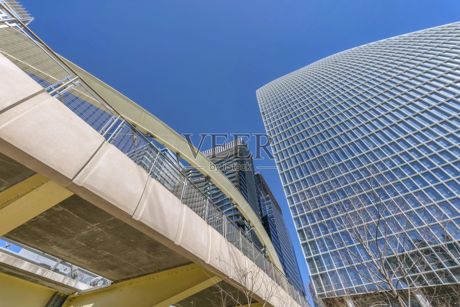 德克萨斯州奥斯汀市——从下面看两座现代建筑之间的桥照片摄影图片