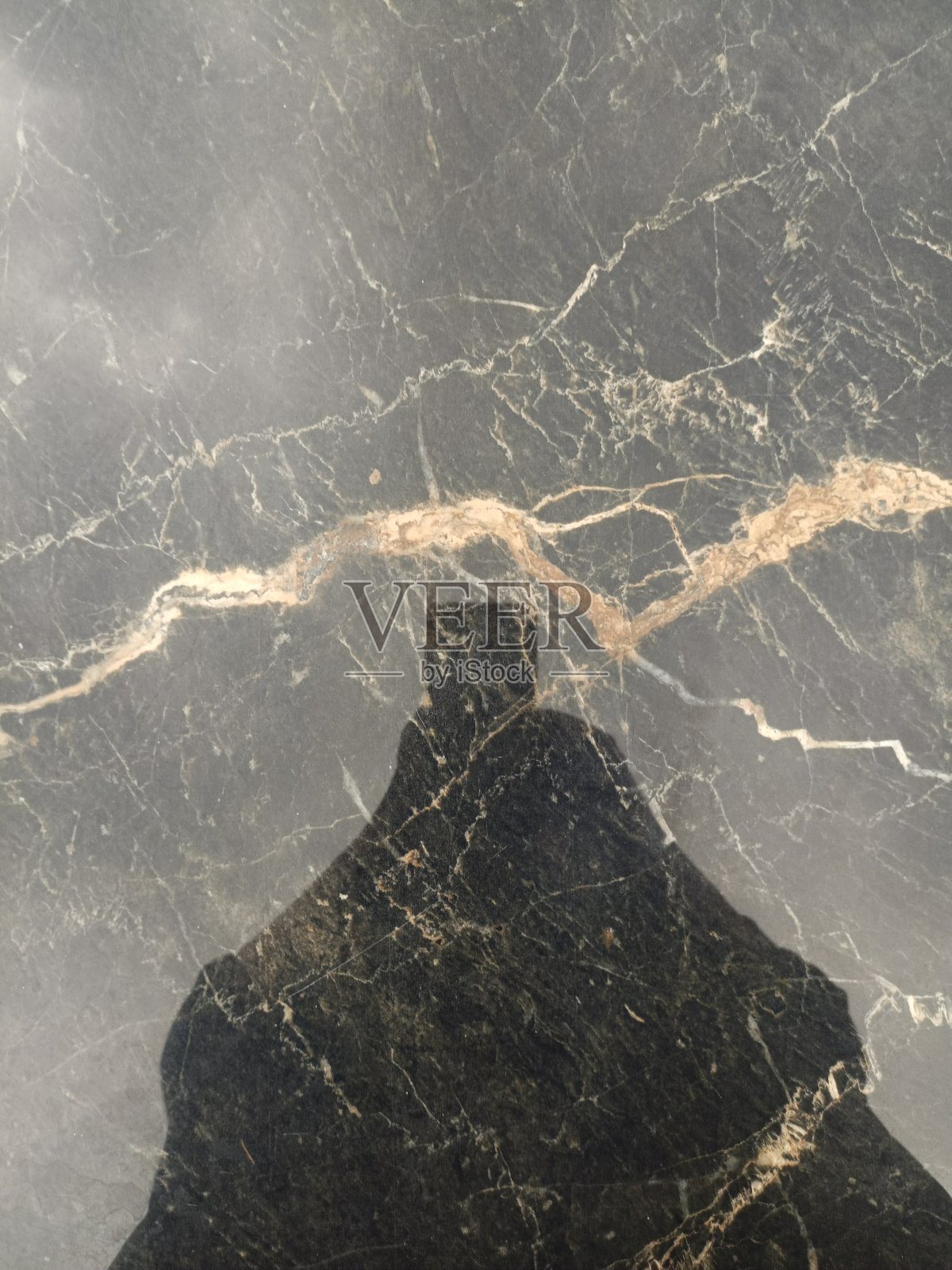 一个人拿着智能手机从低角度拍摄一个物体的影子照片摄影图片