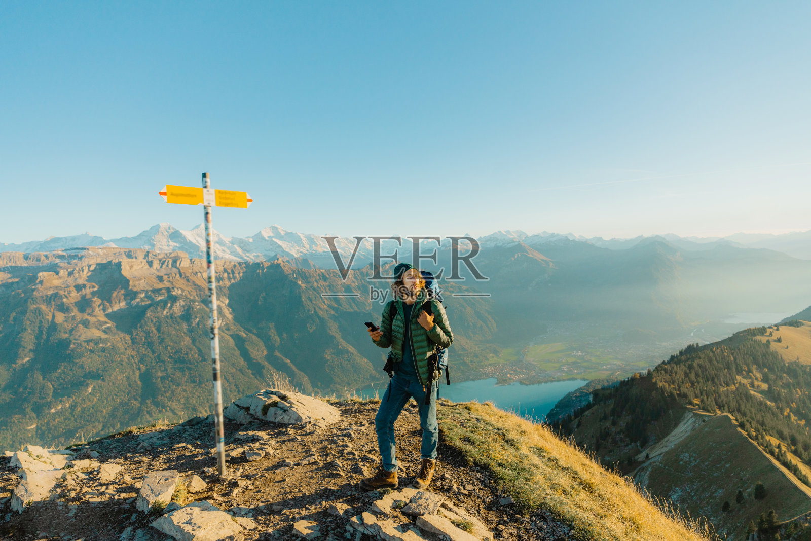 男子徒步旅行的背景因特拉肯在瑞士阿尔卑斯山附近的路标照片摄影图片