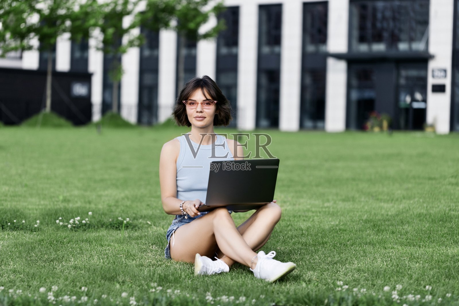 美丽的微笑女孩在公园里用笔记本电脑工作照片摄影图片