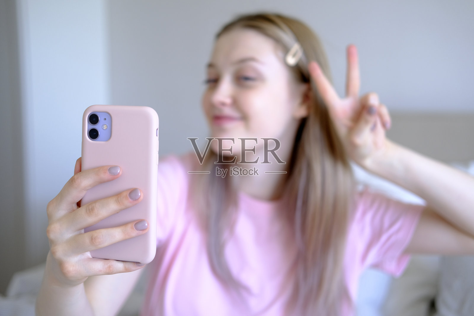 15-18岁的可爱女孩坐在床上自拍。照片摄影图片