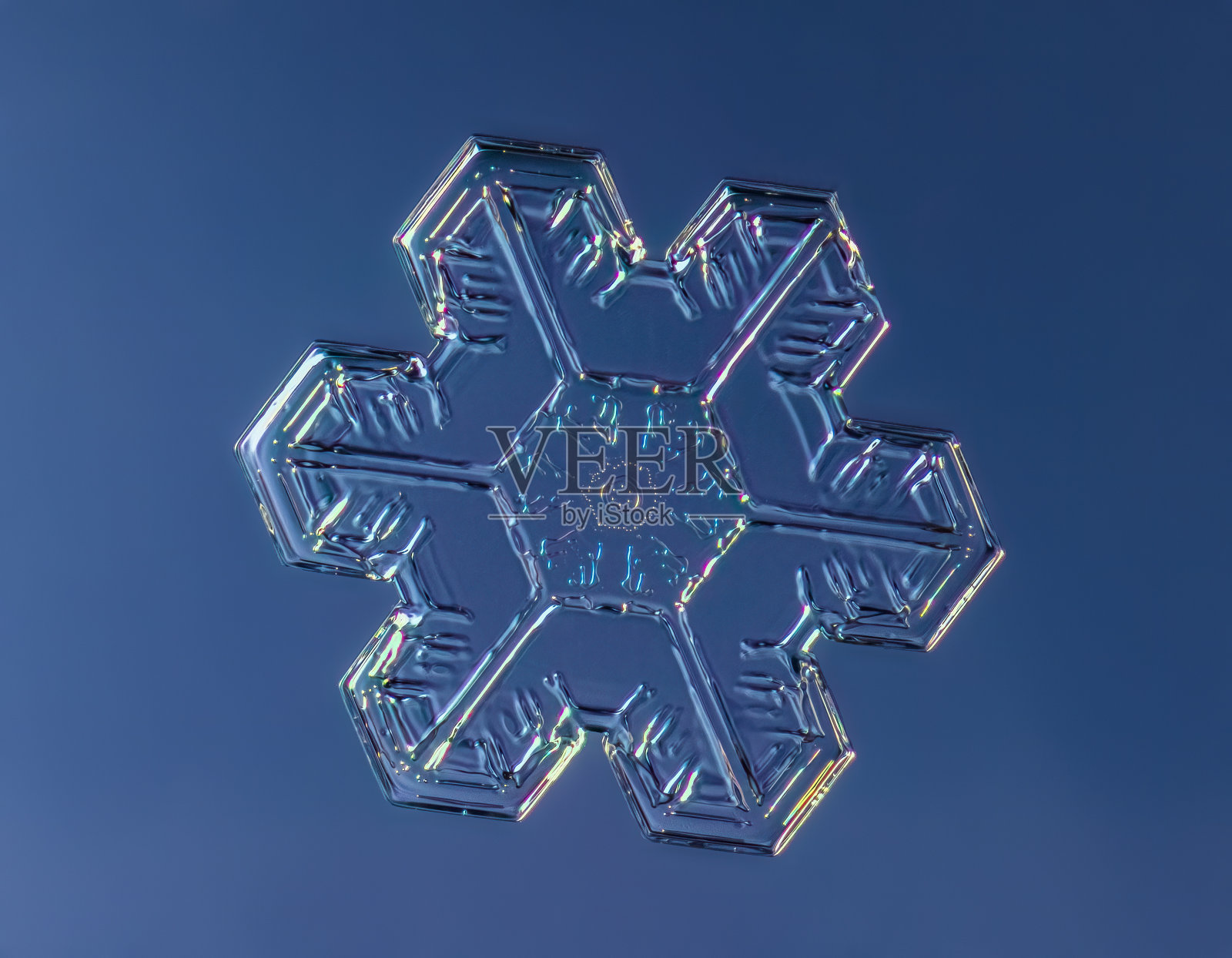 雪花在平滑的渐变背景。微距照片的真正雪水晶玻璃表面。这是一个图案不寻常的小雪花晶体照片摄影图片