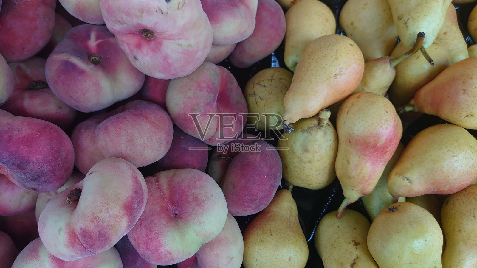 质地的桃子和梨堆在市场上照片摄影图片