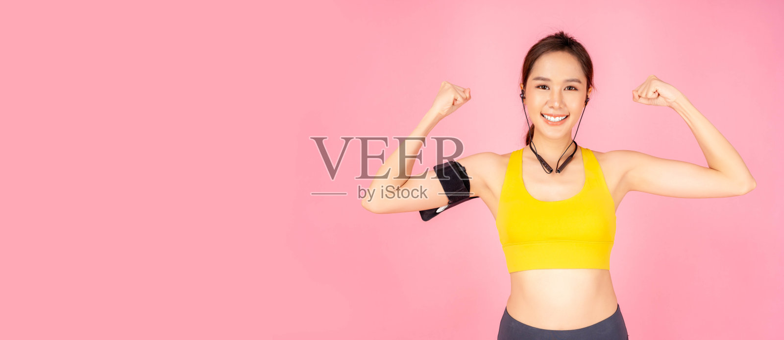 强壮有力的年轻亚洲女性显示肱二头肌手臂举起做强有力的手势微笑的女孩看着相机孤立在粉红色的背景复制空间保健和运动概念她有良好的健康照片摄影图片