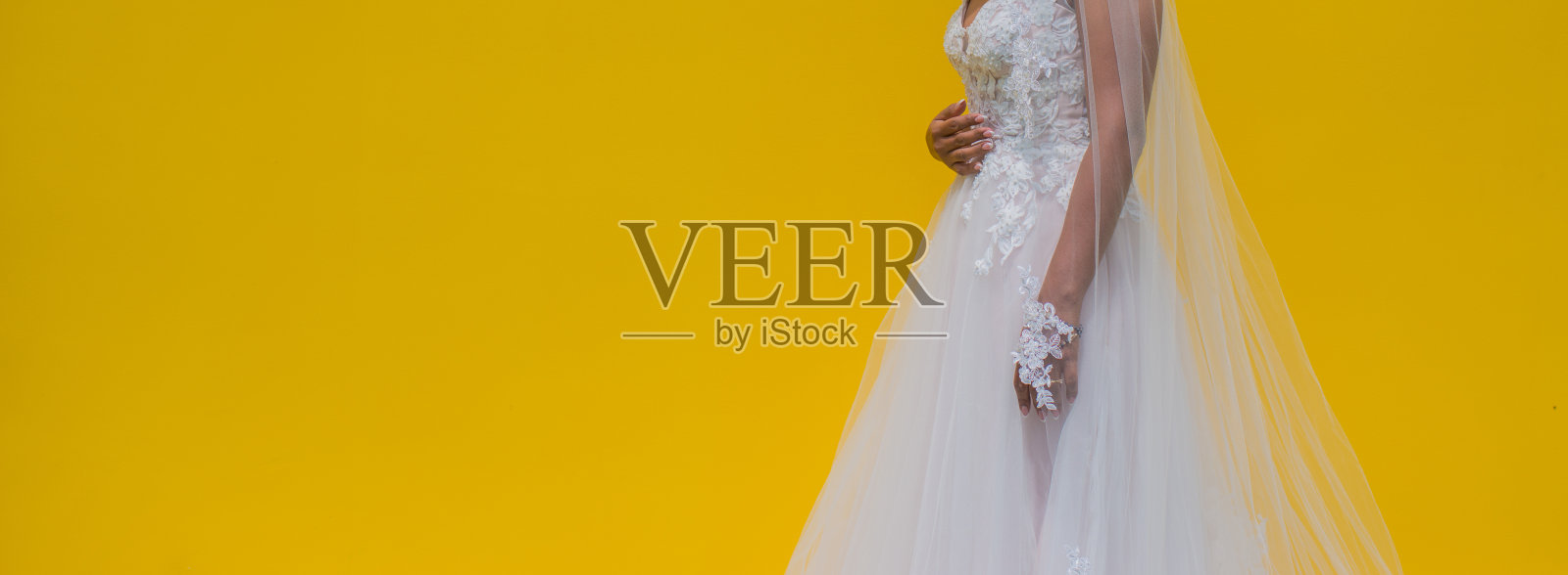 在黄色背景上的婚纱的特写女人照片摄影图片