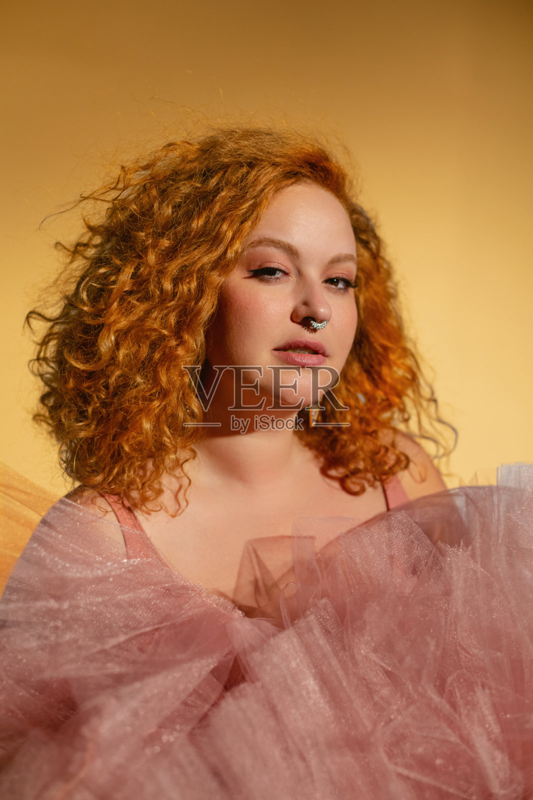 幸福美丽的女人在豪华的闪光的粉红色连衣裙照片摄影图片