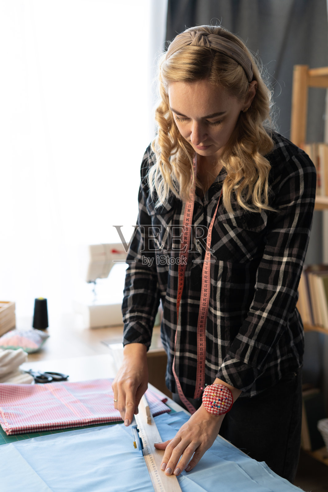 裁缝用缝纫刀在素描线上裁剪衣服面料。时装设计师裁缝或下水道在工作室设计新的服装系列。爱好就是事业照片摄影图片