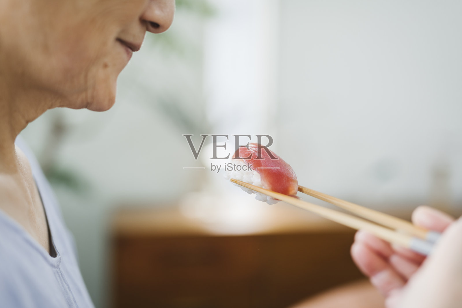亚洲老年妇女吃寿司的手照片摄影图片