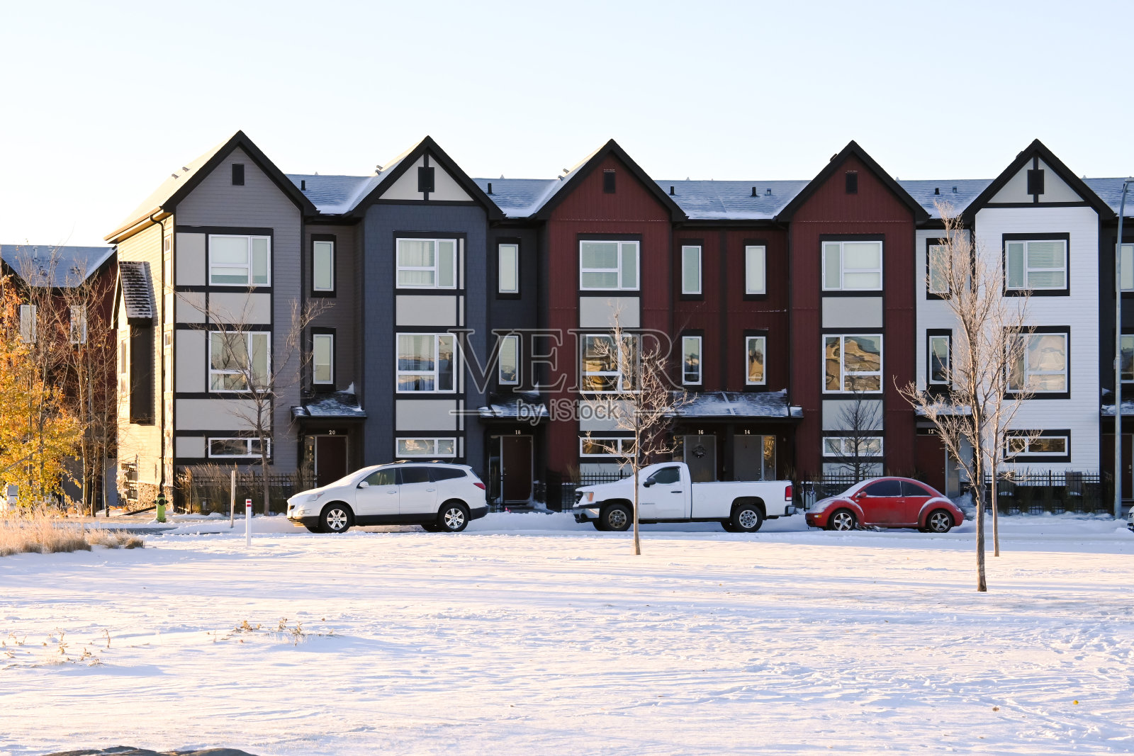 在一个下雪的早晨，从邻近的城市公园望去，一排排的联排别墅照片摄影图片