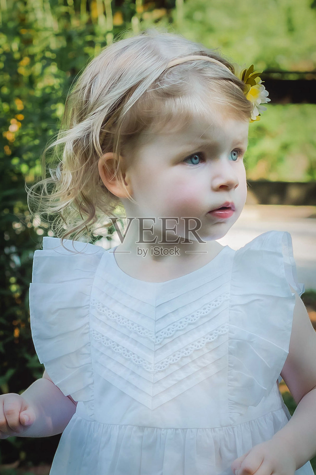在公园里穿白裙子的小女孩照片摄影图片