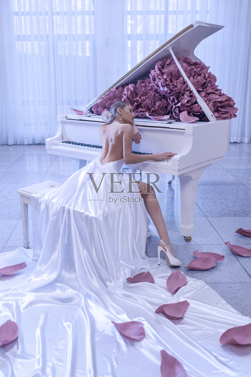 美丽的女人，白色的钢琴和牡丹花在白色的工作室照片摄影图片