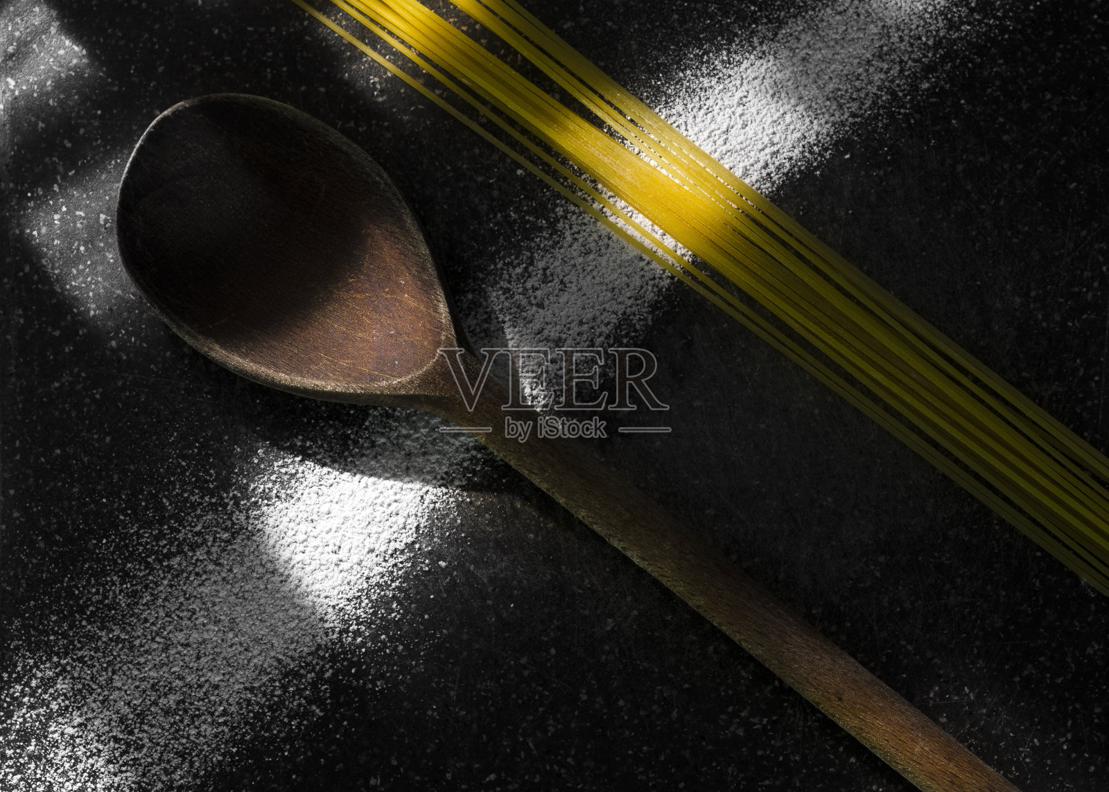 俯视图的木勺附近的意大利面在黑色的桌子上照片摄影图片