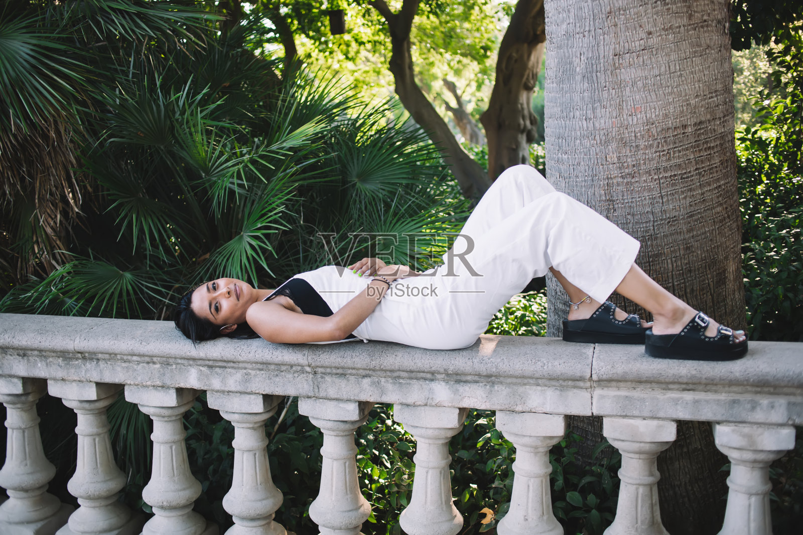 有吸引力的白人年轻20多岁的女人在阳光灿烂的日子里在户外娱乐，美丽的潮女孩游客躺在公园里，满足于夏天度假的自由时间和旅程照片摄影图片